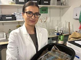 Technician carrying a tray of test tubes
